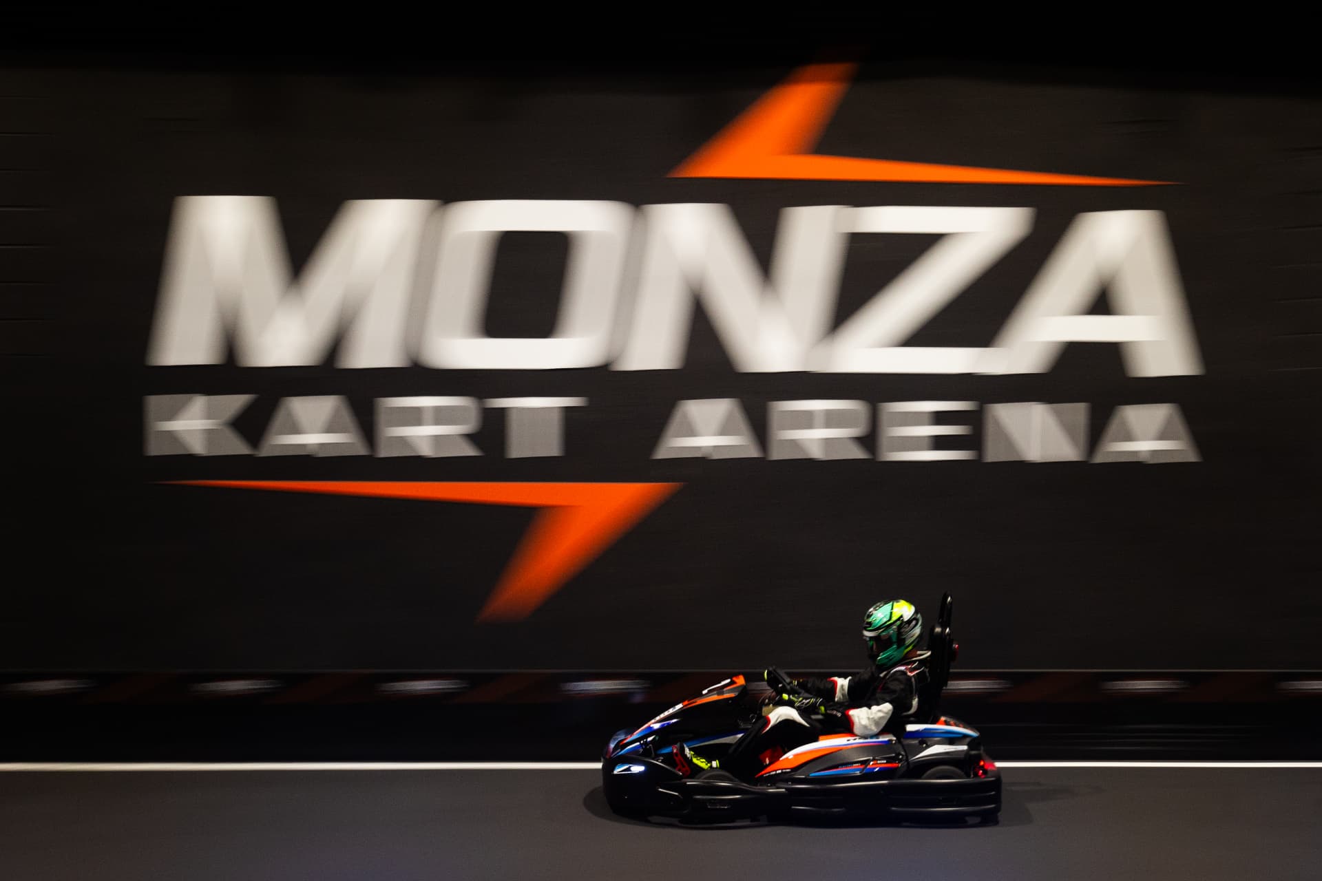 Kart in pista davanti al muro brandizzato Monza Kart Arena